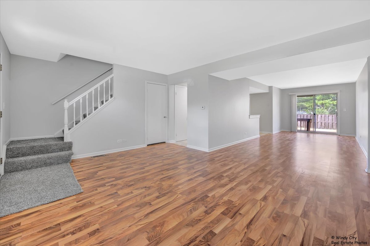 936 Cardiff Court Schaumburg, IL 60169 - Photo 2 of 35 a view of an empty room with wooden floor and a window
