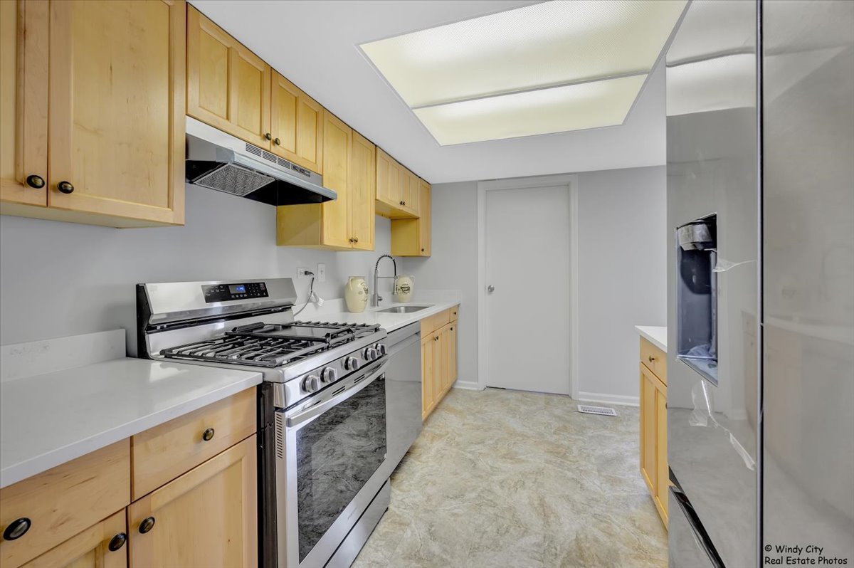 936 Cardiff Court Schaumburg, IL 60169 - Photo 7 of 35 a kitchen with stainless steel appliances granite countertop a stove and a refrigerator