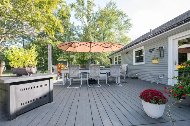 a balcony with wooden floor table and chairs