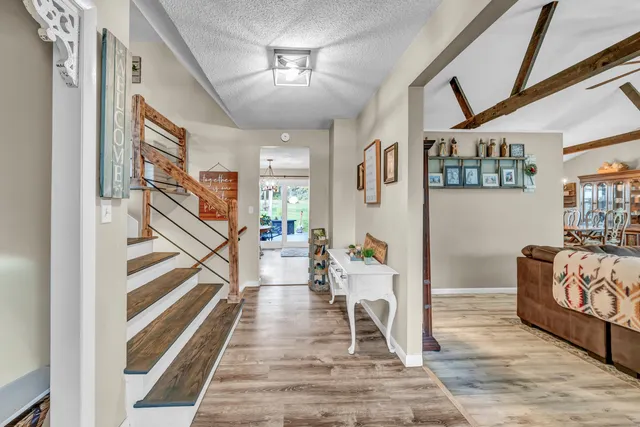 a view of a hallway with wooden floor and staircase