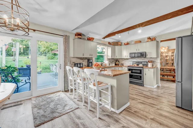 a kitchen with a stove a refrigerator and wooden floor