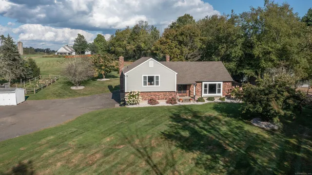 a house with green field in front of it