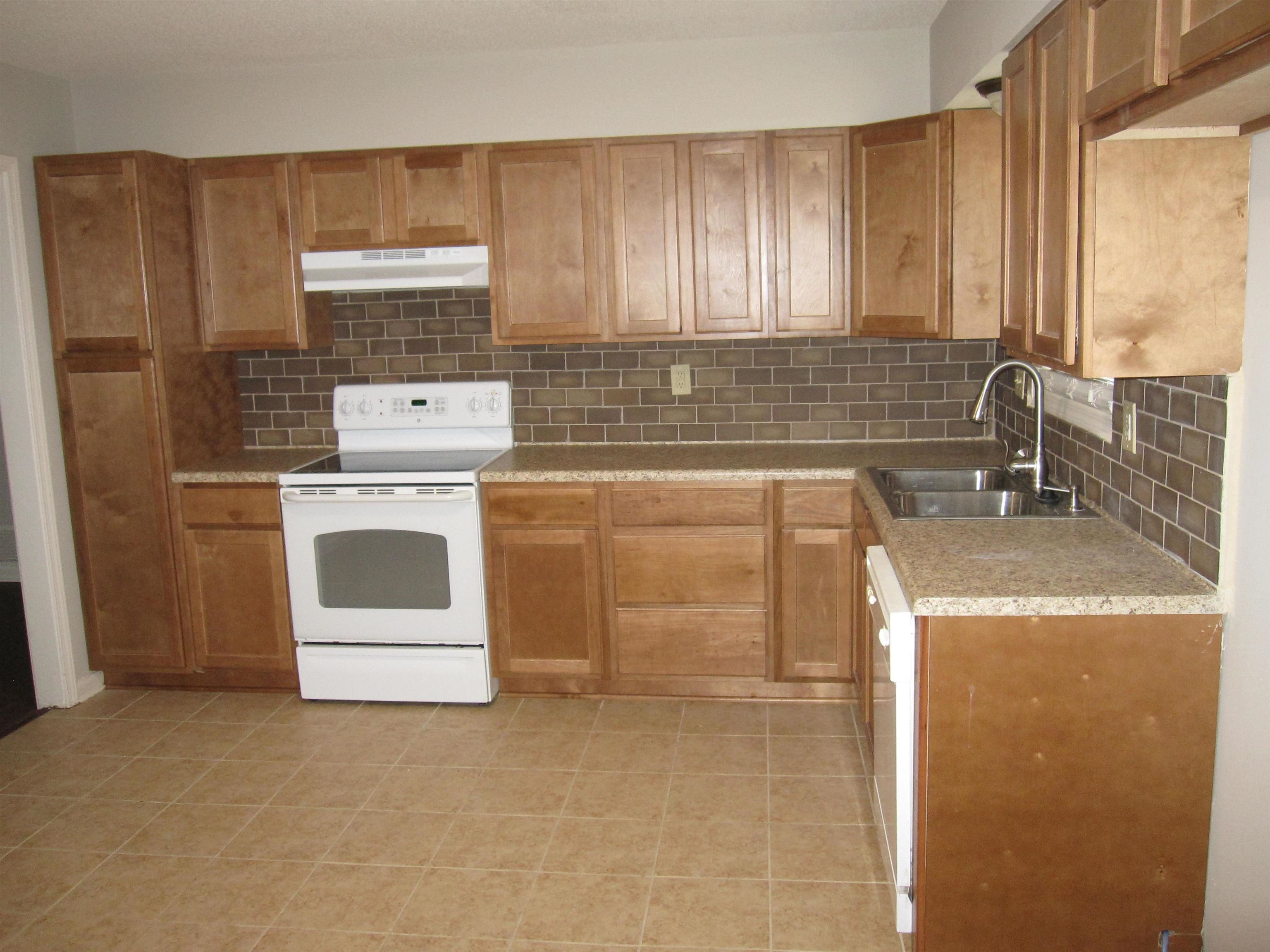 935 Poplar Leaf Road Collierville, TN 38017 - Photo 2 of 19 a kitchen with a stove top oven and cabinets