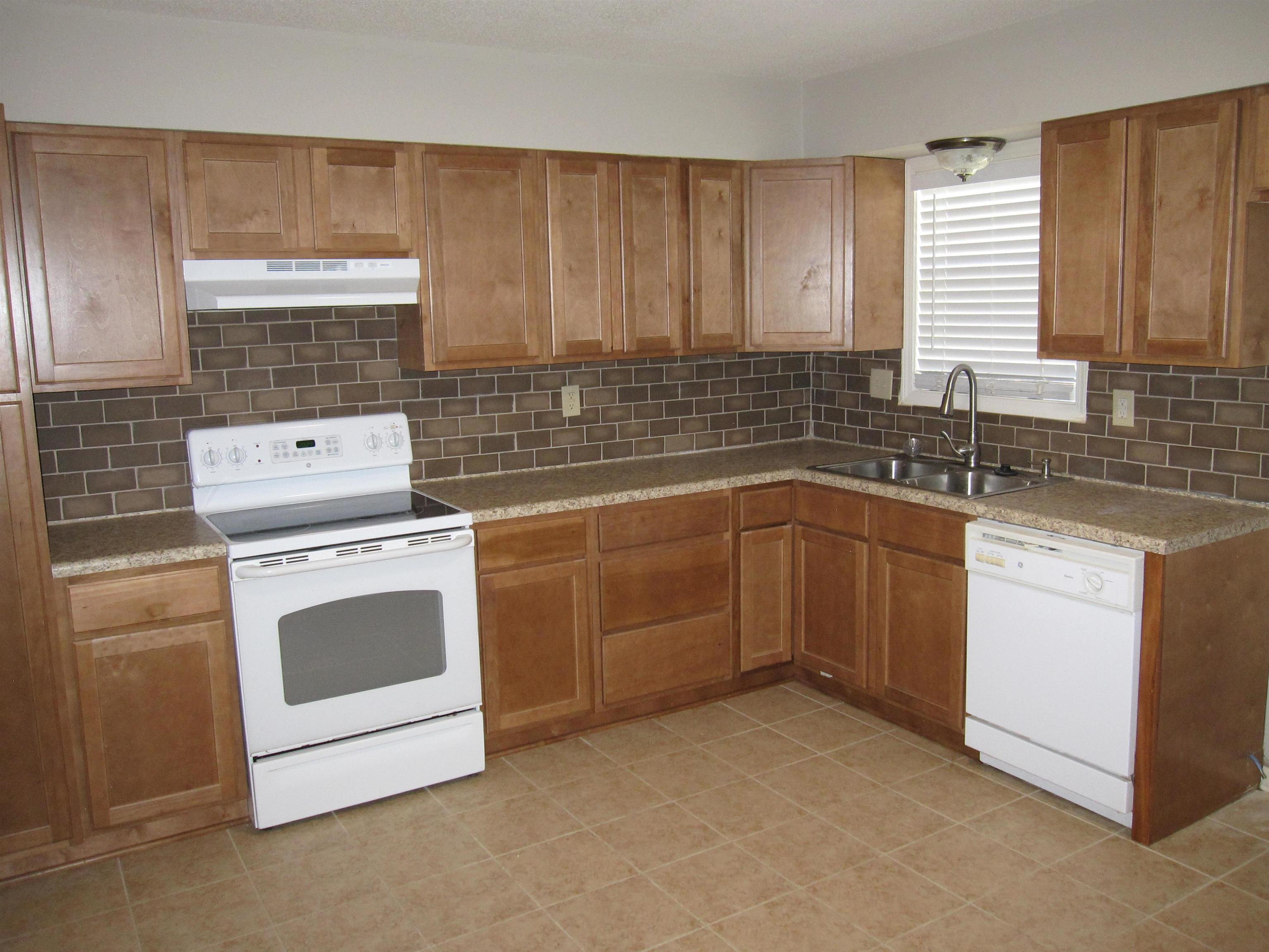 935 Poplar Leaf Road Collierville, TN 38017 - Photo 4 of 19 a kitchen with a sink stove and cabinets