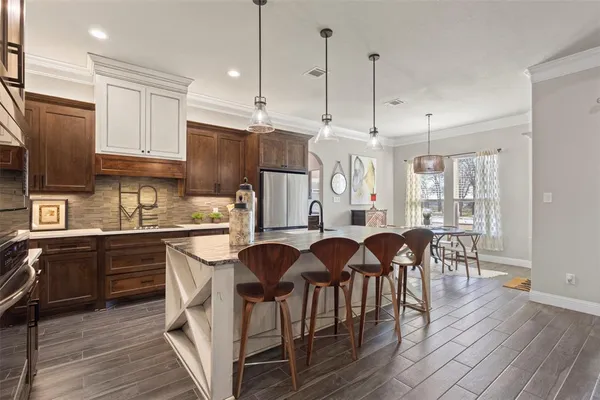 a kitchen with granite countertop a center island a sink stainless steel appliances and cabinets