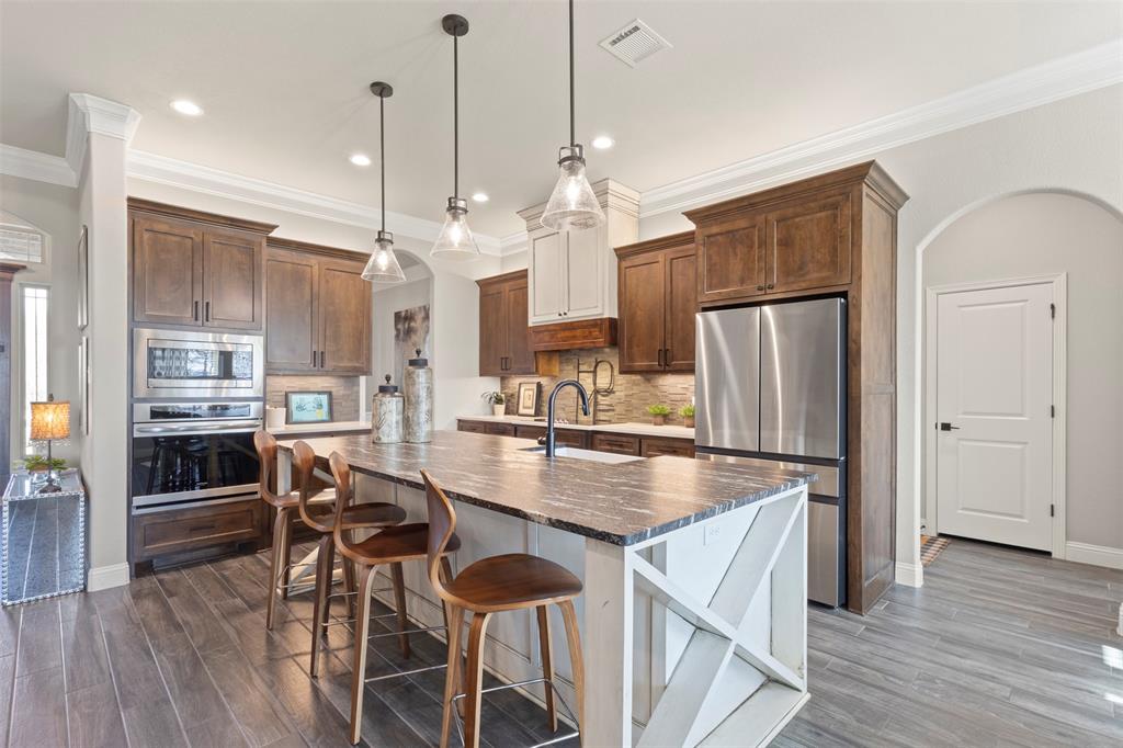 703 Winkler Way Springtown, TX 76082 - Photo 14 of 37 a kitchen with stainless steel appliances granite countertop a refrigerator a stove and a wooden floors