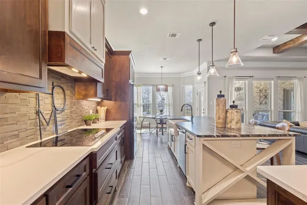 a kitchen with stainless steel appliances granite countertop a sink a stove and a wooden floors