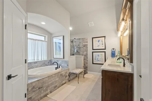 a spacious bathroom with sink shower and bathtub