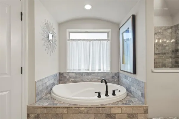 a bathroom with bathtub and window