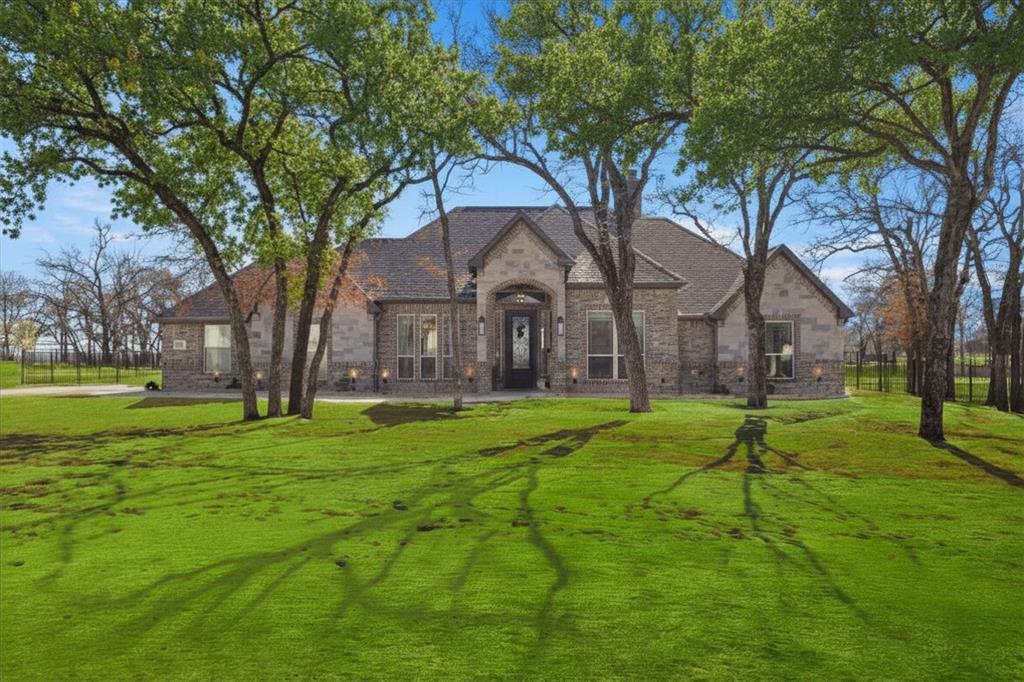 703 Winkler Way Springtown, TX 76082 - Photo 2 of 37 a house with huge green field in front of it