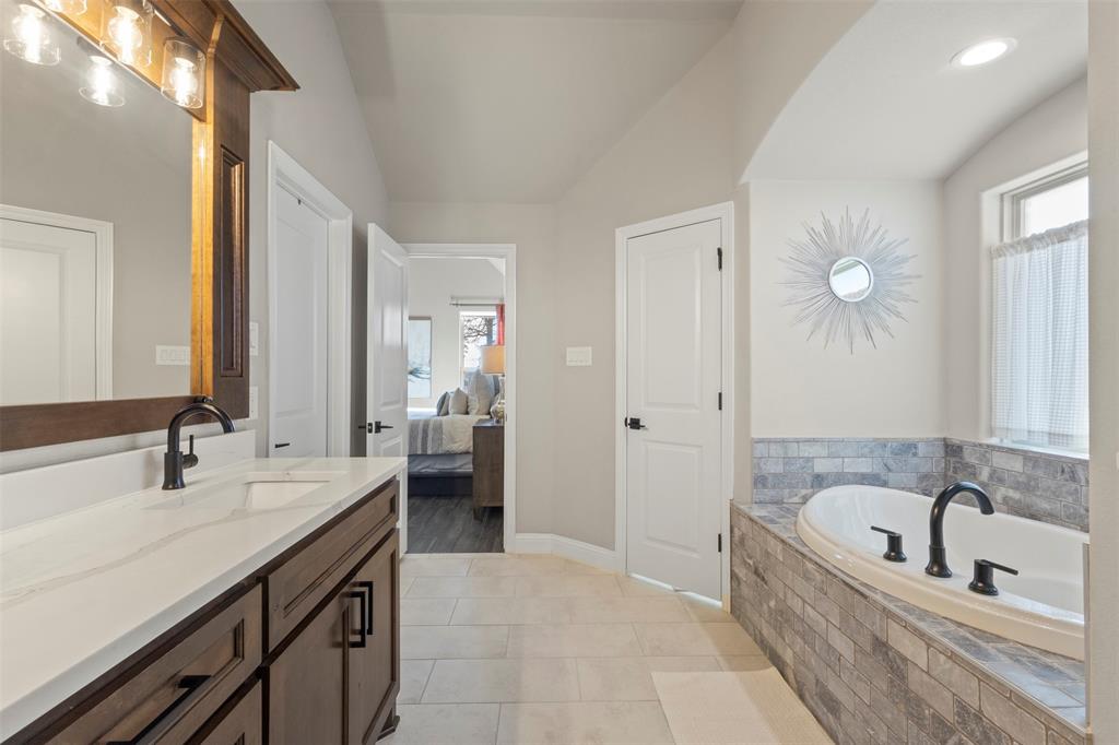 703 Winkler Way Springtown, TX 76082 - Photo 21 of 37 a spacious bathroom with a bathtub sink and mirror