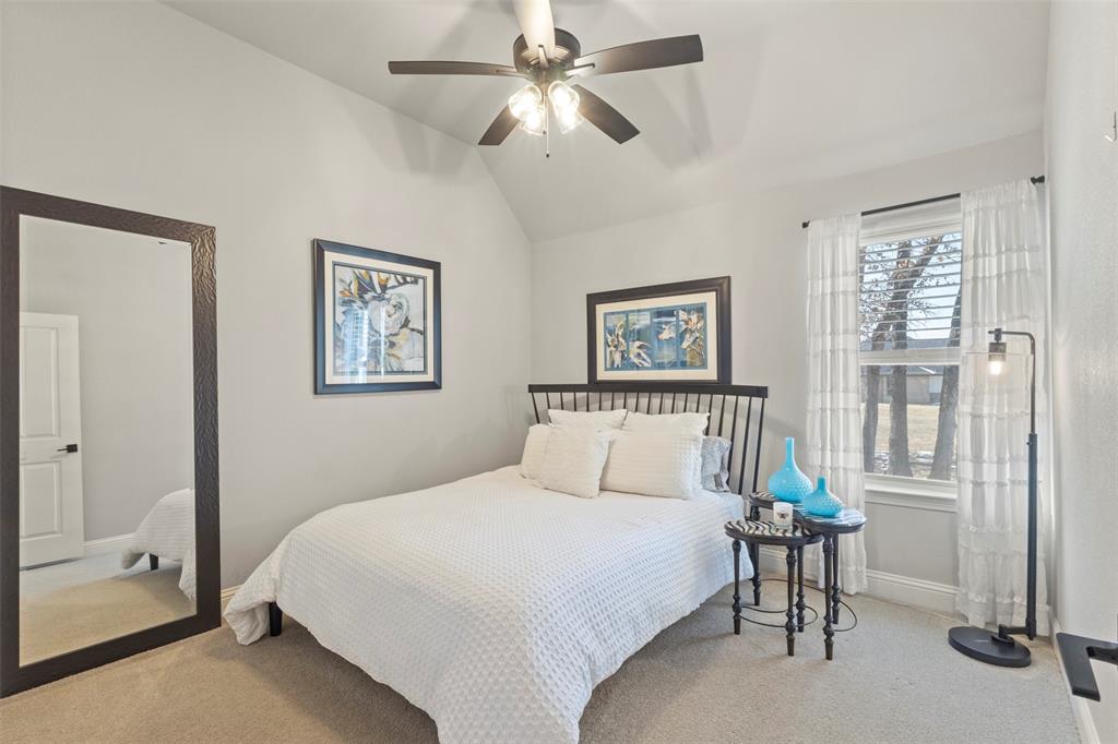 703 Winkler Way Springtown, TX 76082 - Photo 23 of 37 a bedroom with a bed and a chandelier