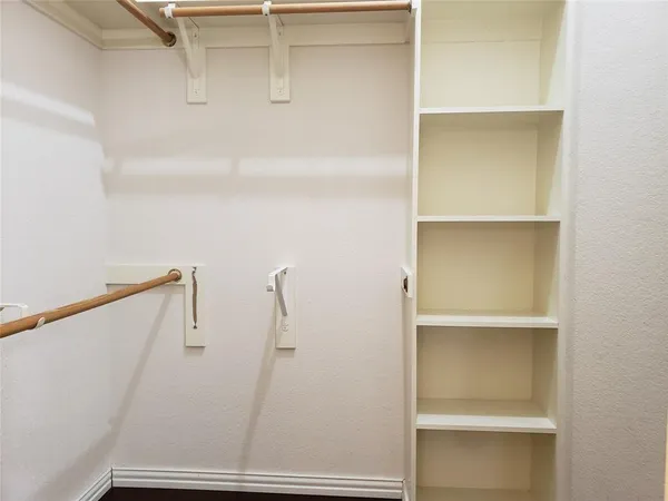 a view of walk in closet with empty racks