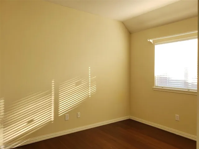 a view of a room with wooden floor and a window