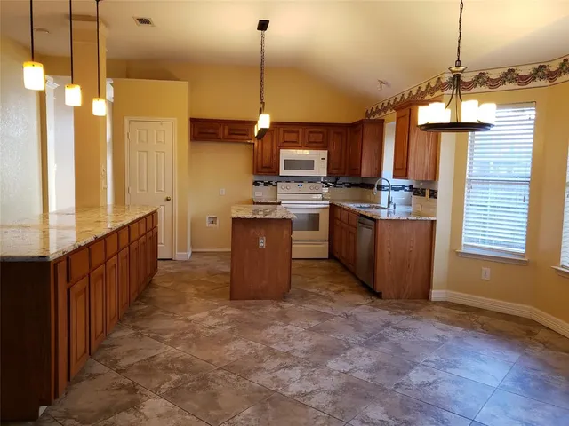a view of a kitchen with stainless steel appliances granite countertop furniture and a wooden floor