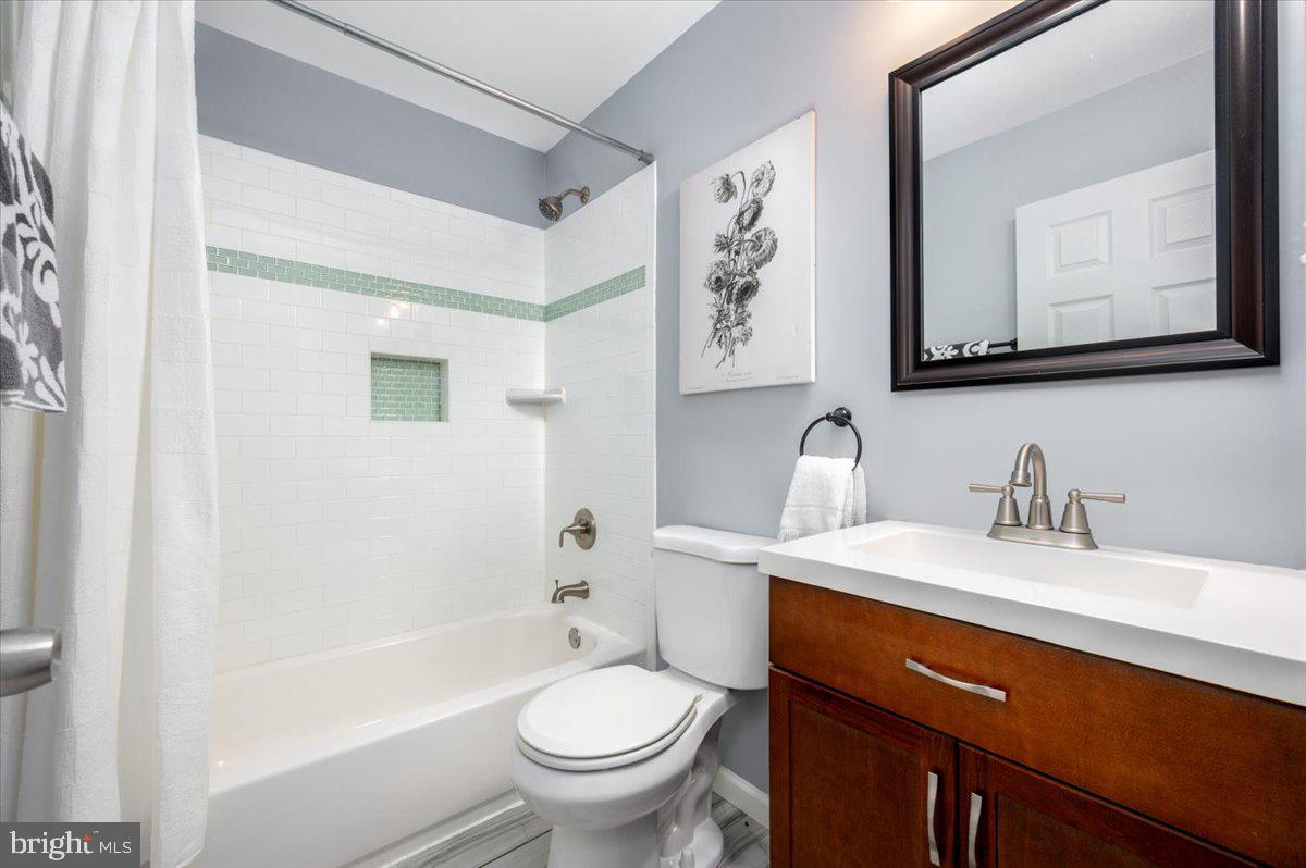 7804 East A E Shore Road Pasadena, MD 21122 - Photo 15 of 34 a bathroom with a toilet sink vanity tub and mirror