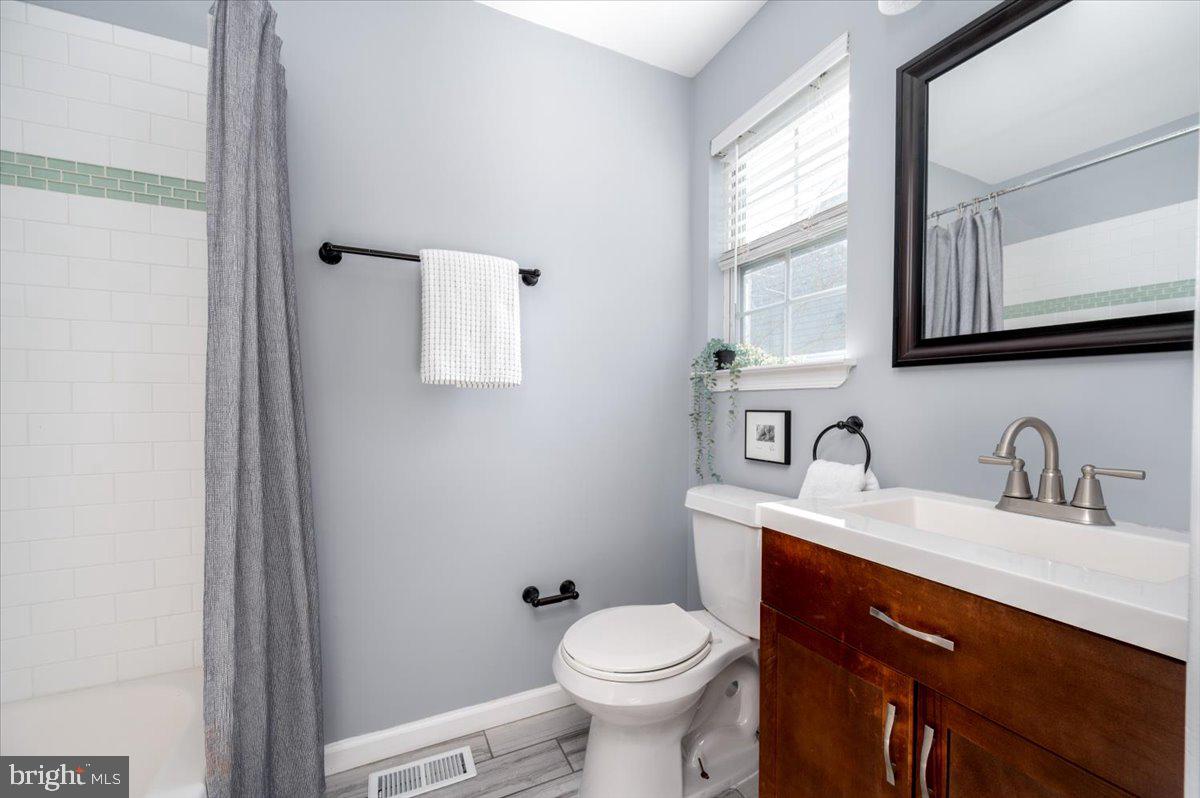 7804 East A E Shore Road Pasadena, MD 21122 - Photo 21 of 34 a bathroom with a granite countertop toilet sink and mirror