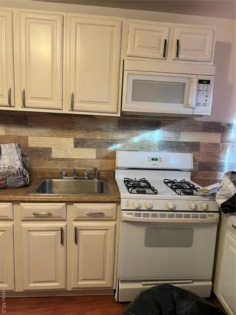 a stove top oven sitting inside of a kitchen