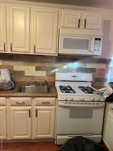 a stove top oven sitting inside of a kitchen