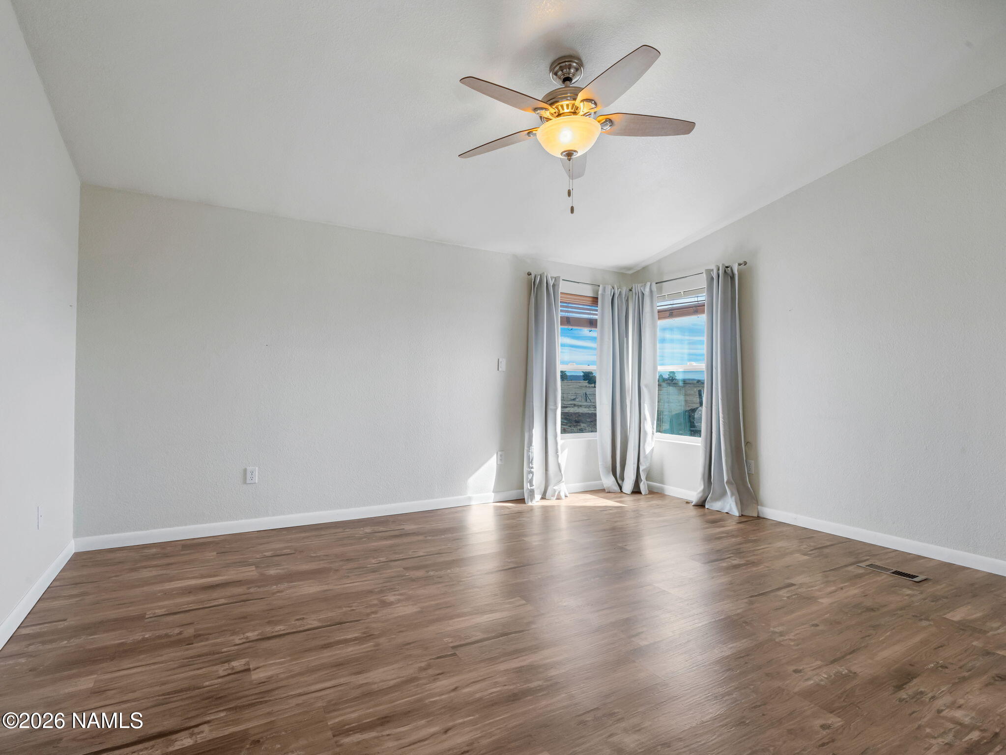3095 North Peak View Road Williams, AZ 86046 - Photo 13 of 37 a view of an empty room with a window and wooden floor