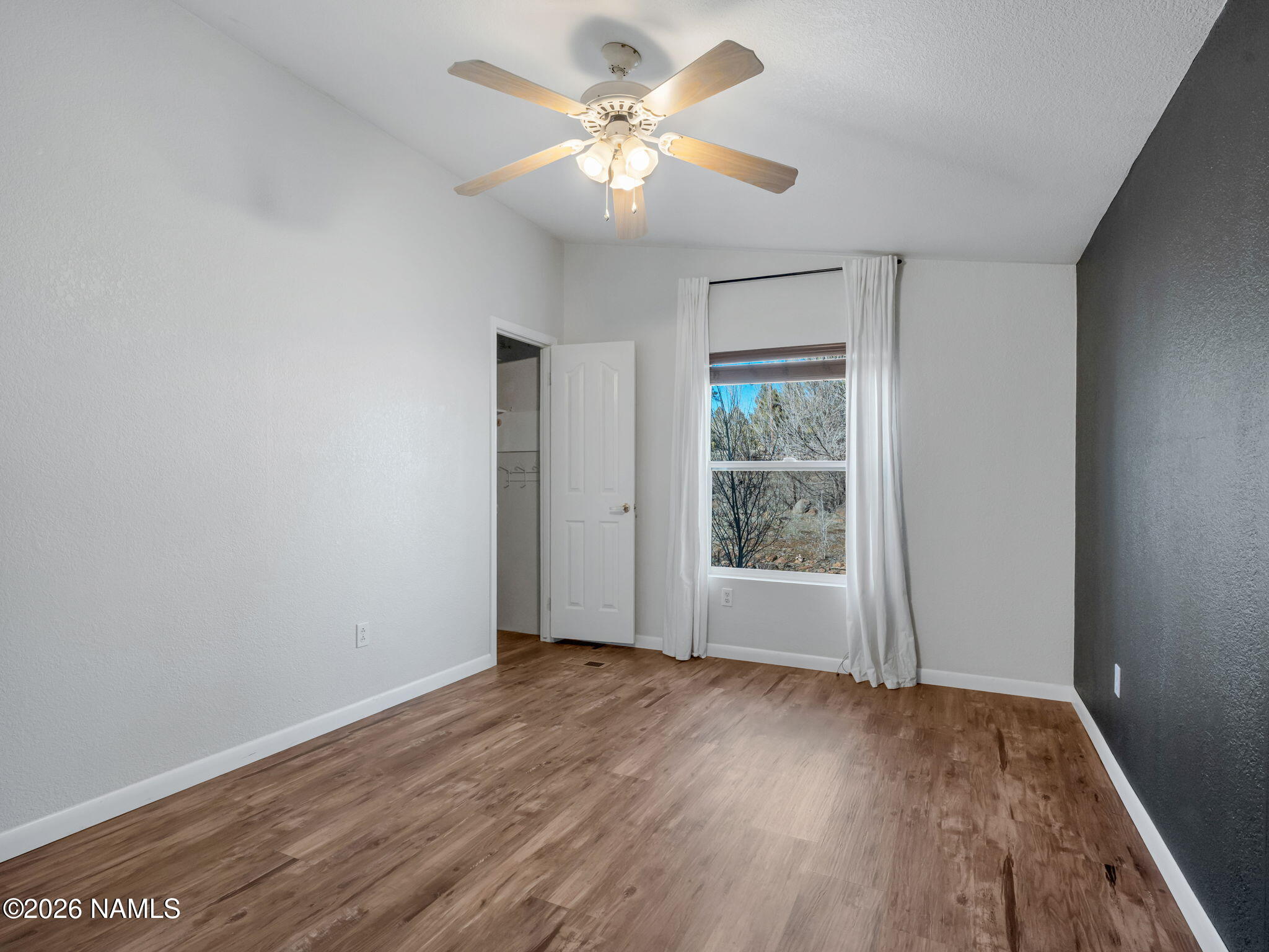 3095 North Peak View Road Williams, AZ 86046 - Photo 21 of 37 wooden floor in an empty room with a window