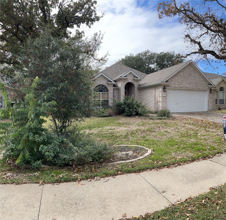 a view of a yard in front of a house with large tree