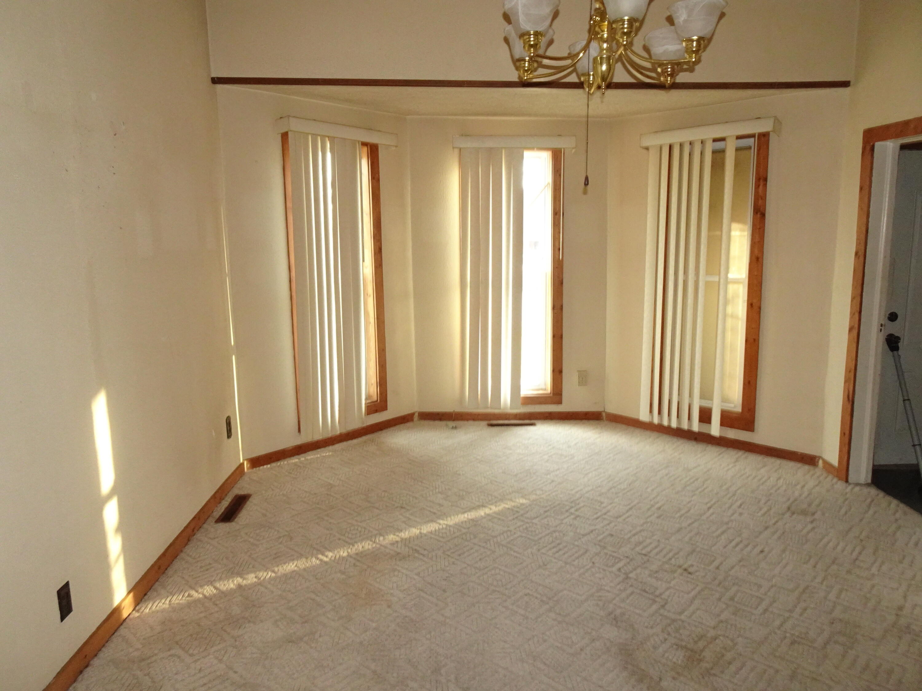 330 East Elm Street Rensselaer, IN 47978 - Photo 3 of 13 an empty room with a chandelier fan and windows
