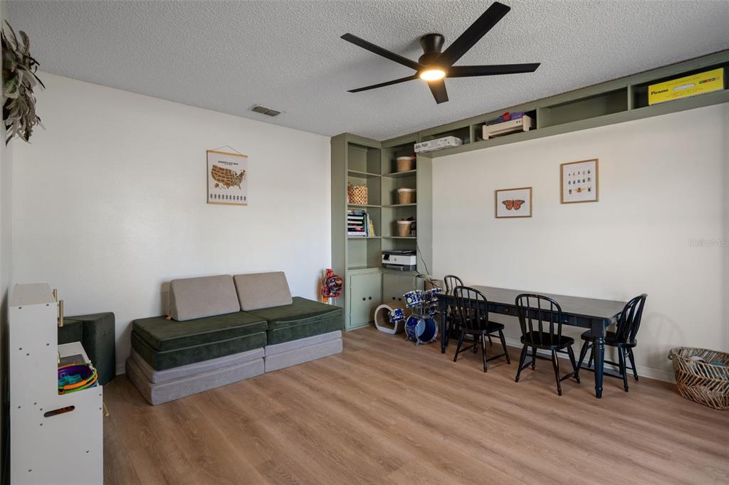 11258 Lomita Wren Road Weeki Wachee, FL 34614 - Photo 11 of 46 a living room with furniture a dining table and a piano next to a window