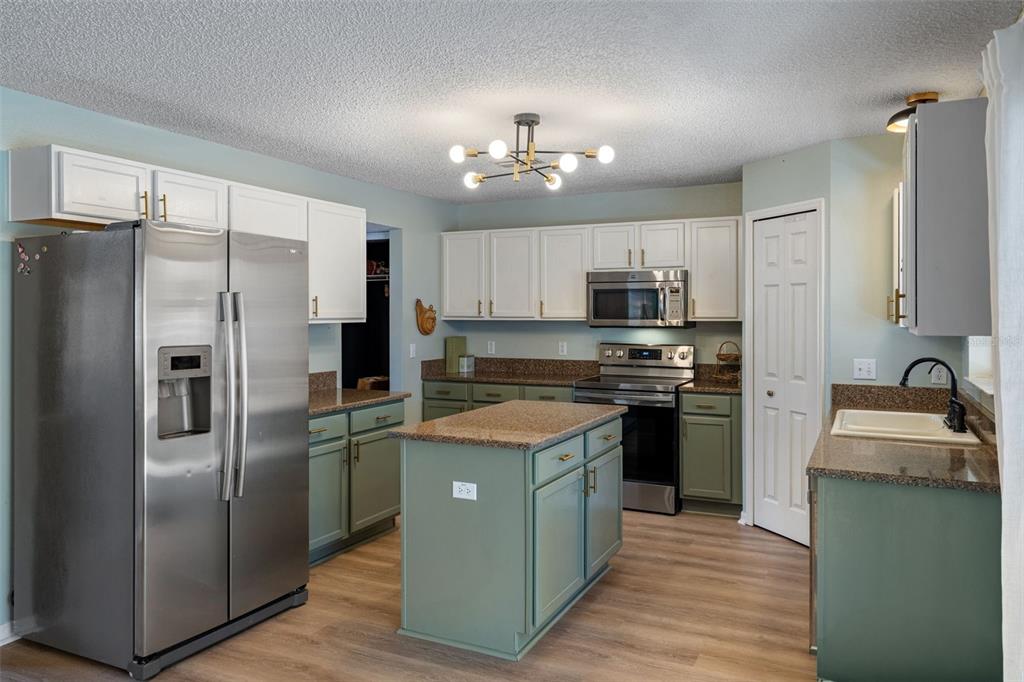 11258 Lomita Wren Road Weeki Wachee, FL 34614 - Photo 14 of 46 a kitchen with kitchen island granite countertop stainless steel appliances and a refrigerator