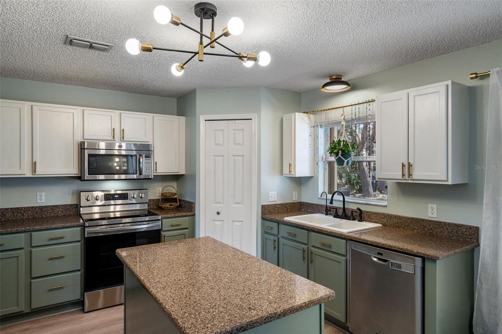 11258 Lomita Wren Road Weeki Wachee, FL 34614 - Photo 16 of 46 a kitchen with a sink stove and microwave