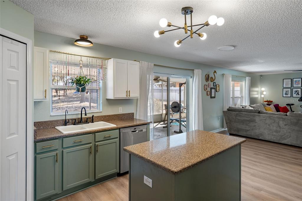 11258 Lomita Wren Road Weeki Wachee, FL 34614 - Photo 19 of 46 a kitchen with a sink dishwasher a stove and white countertops with wooden floor