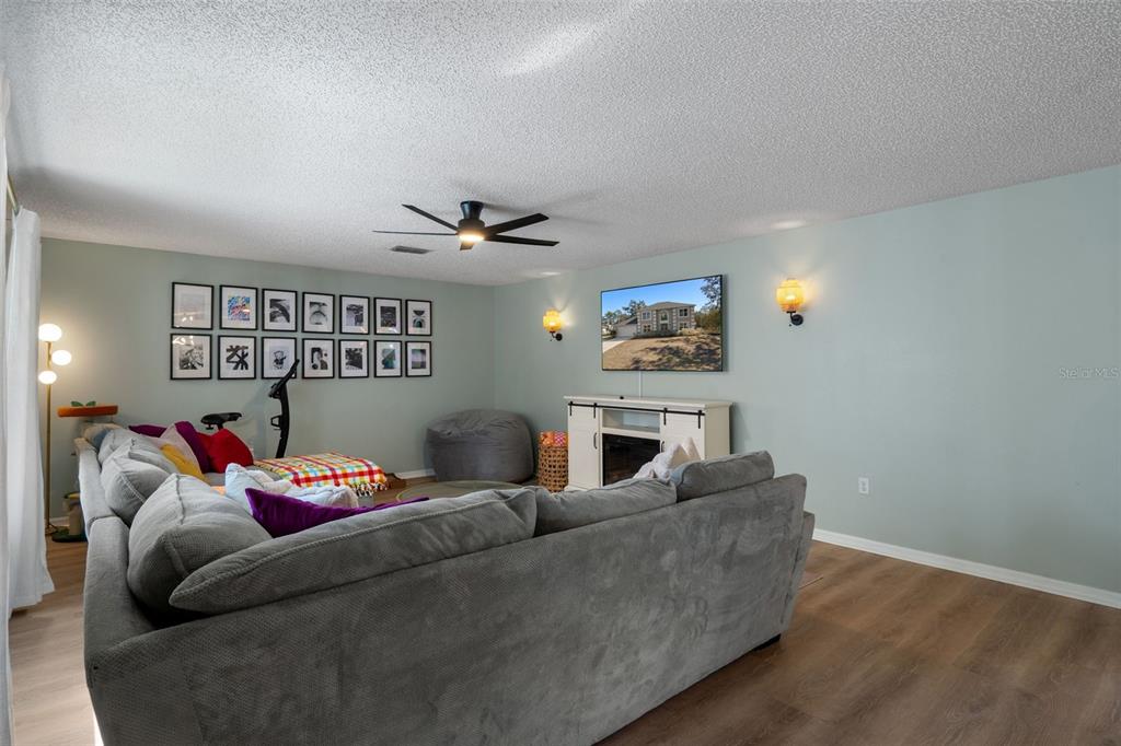 11258 Lomita Wren Road Weeki Wachee, FL 34614 - Photo 22 of 46 a living room with furniture and a wooden floor