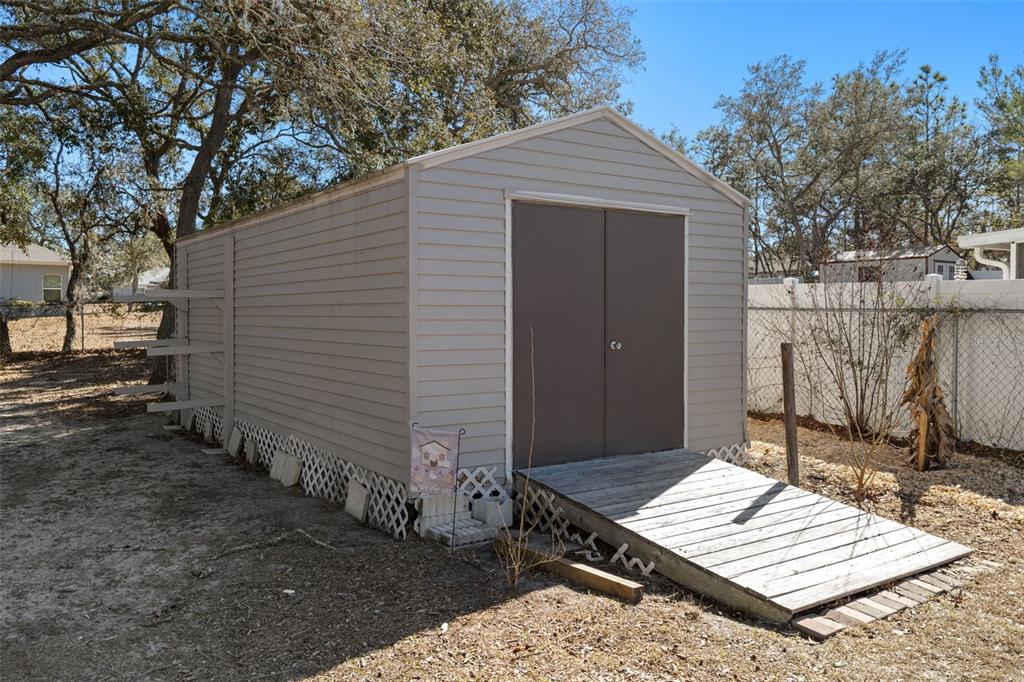 11258 Lomita Wren Road Weeki Wachee, FL 34614 - Photo 44 of 46 a wooden bench sitting in front of a house