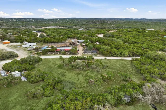 an aerial view of residential houses with outdoor space and trees