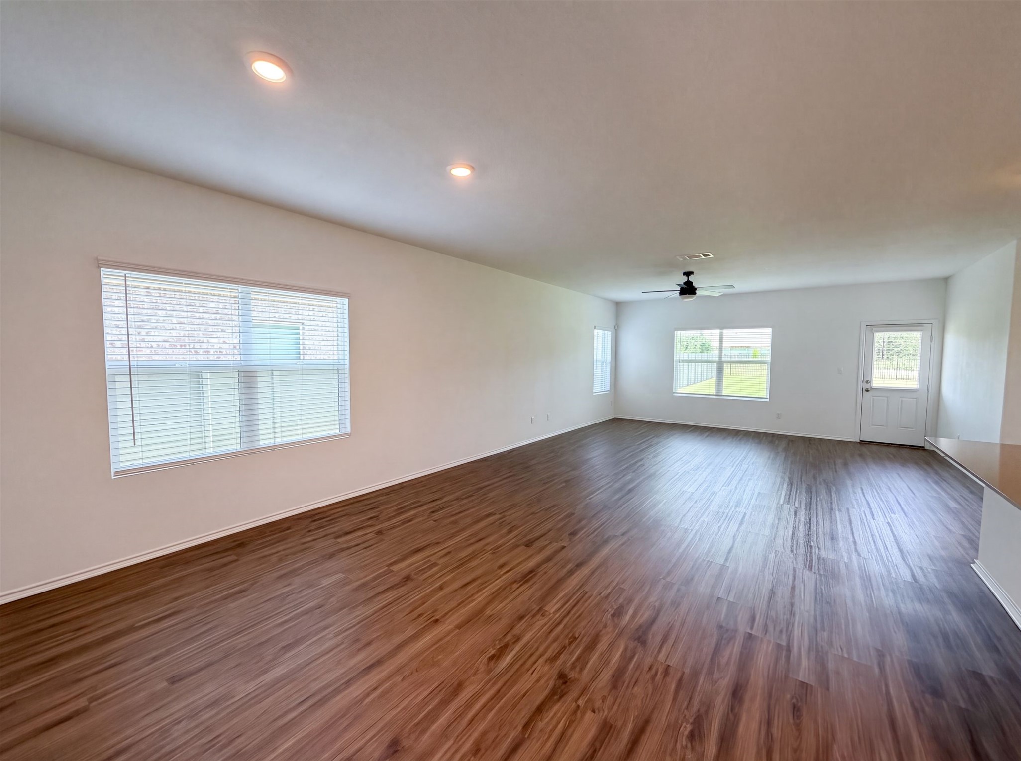 424 Wolf Springs Road Georgetown, TX 78628 - Photo 3 of 15 A spacious room features abundant natural light and rich wood flooring, perfect for versatile living.