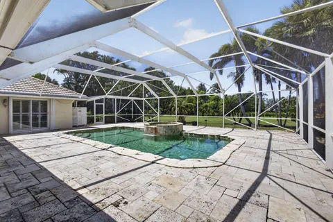 a view of a backyard with floor to ceiling window and wooden fence
