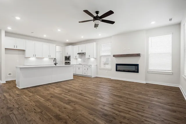 a view of kitchen with stainless steel appliances wooden floor and a window