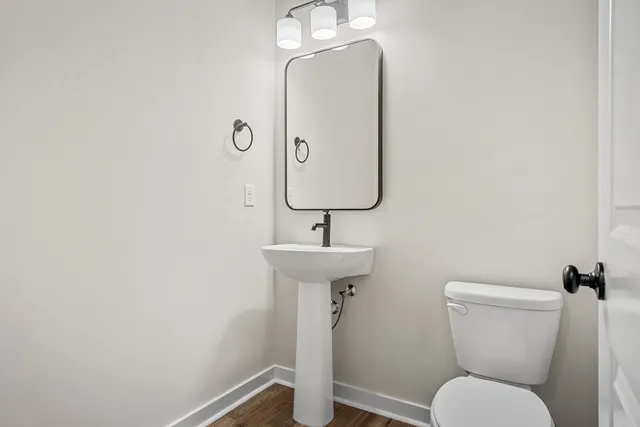 a bathroom with a toilet sink and mirror