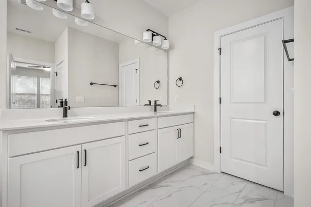 a bathroom with double sink and a mirror