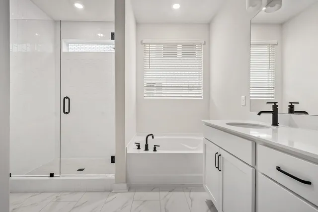 a bathroom with a tub sink and mirror