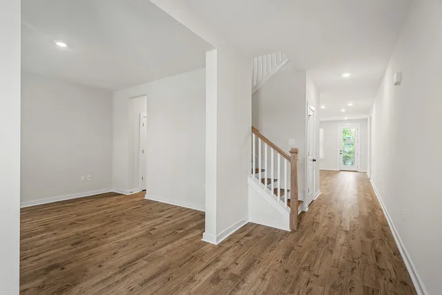 a view of a hallway with wooden floor and staircase