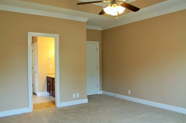 a view of an empty room with a chandelier fan
