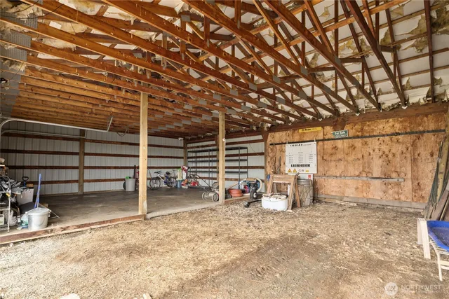 a view of a lake with lawn chairs and large tree