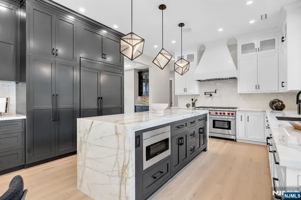 a kitchen with stainless steel appliances granite countertop a stove a sink and a refrigerator