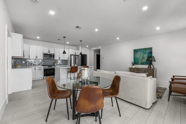 a kitchen with stainless steel appliances granite countertop a refrigerator a stove a sink and a refrigerator with wooden floor