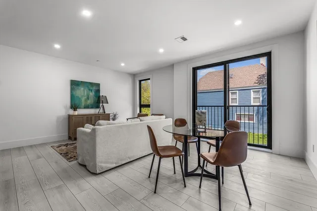 a kitchen with a dining table chairs wooden floor and appliances