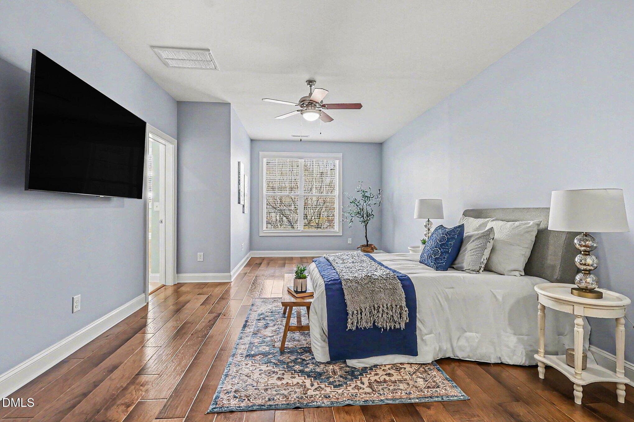653 Fallon Grove Way Raleigh, NC 27608 - Photo 19 of 38 a bed room with bed and a flat screen tv