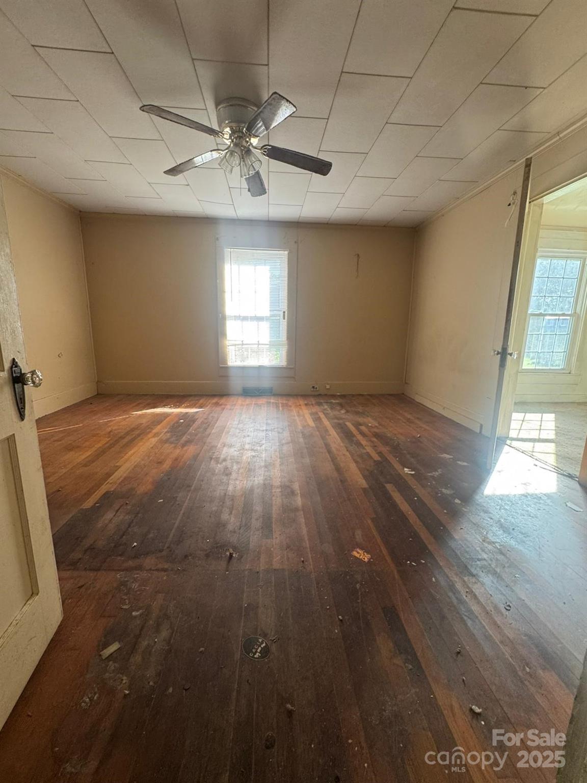 65 Maynard Avenue Ansonville, NC 28170 - Photo 2 of 14 an empty room with wooden floor fan and windows
