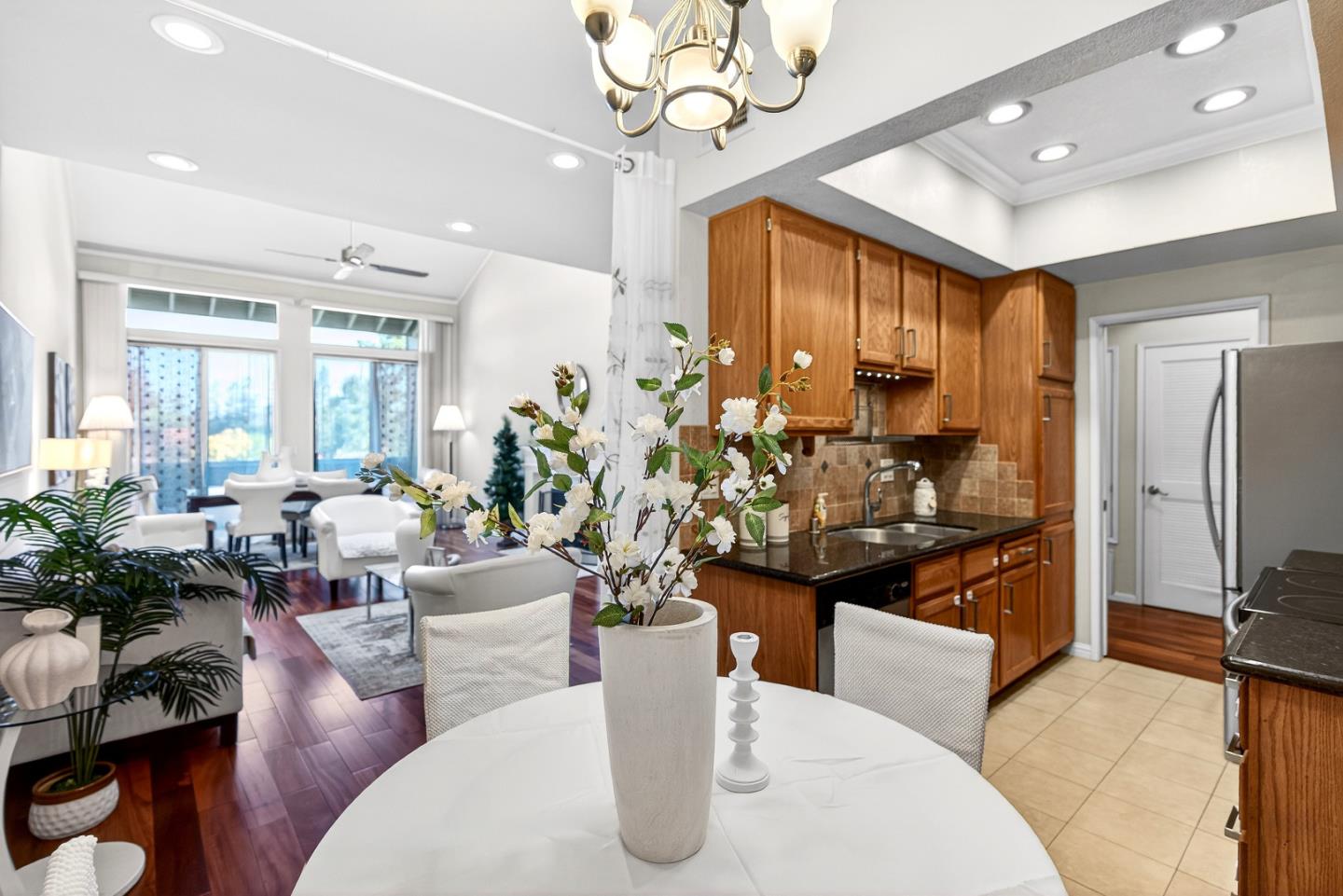 22330 Homestead Road, Unit 214 Cupertino, CA 95014 - Photo 8 of 35 a living room with stainless steel appliances kitchen island granite countertop furniture a rug kitchen view and a chandelier