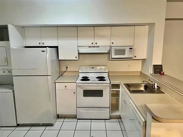 a kitchen with a stove a sink and a refrigerator